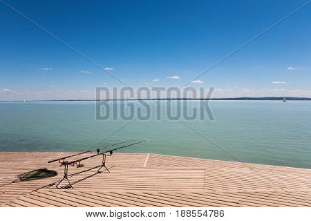 Fishing rods on wooden pier at Lake Balaton Hungary
