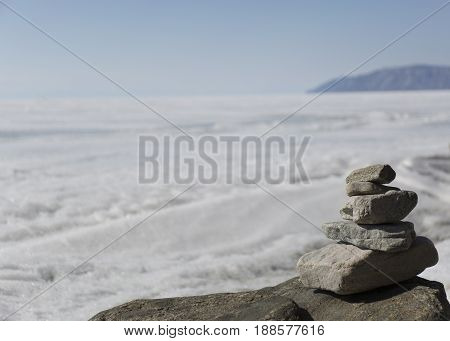 Stone tower on ice winter background. Baical landscape