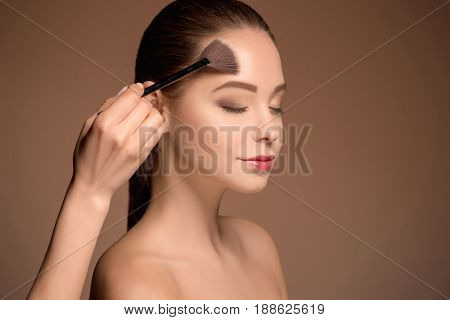 Beauty Girl with Makeup Brush. Bright Make-up for Brunette Woman with Beautiful Face. Perfect Skin. Applying Makeup