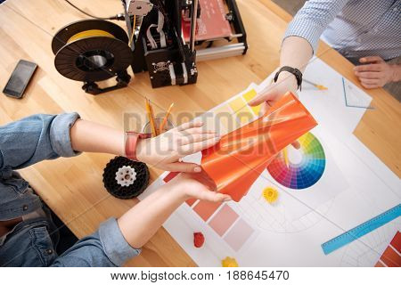 Printed object. Top view of a 3d printed vase being handed over to a male 3d designer