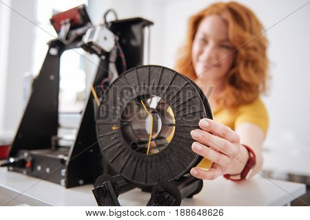 3d printer details. Selective focus of a 3d printer filament being held by a nice pleasant female designer while working with 3d technology