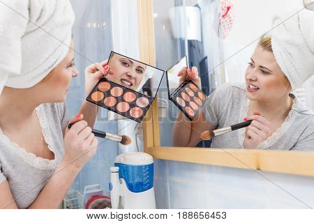Woman In Bathroom Applying Contour Bronzer On Brush