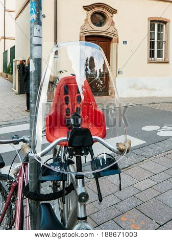 Modern bicycle with red security confor child seat in city environemnt