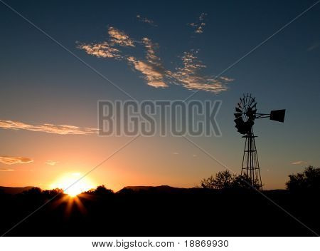 Silhueta de um moinho de vento ao pôr do sol no Karoo