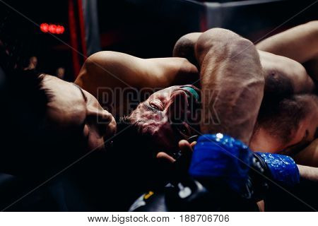 TOMSK, RUSSIA - February 12, 2017: GRAND PRIX  Power Club on MMA. Varos Tadevosyan VS Kerimbayev Altnybek. Boxers fighters  fight in fights without rules in the ring octagon.Toning