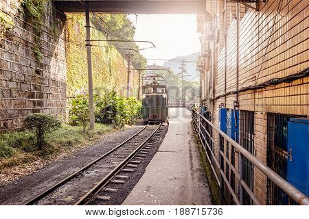 Electric narrow-gauge locomotive with the coal loaded freight train moves through Yuejin town to Shixi. Jiayang Mining Region. Sichuan province. China.