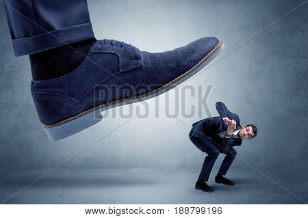 Big foot trying to crush small man who is afraid of that