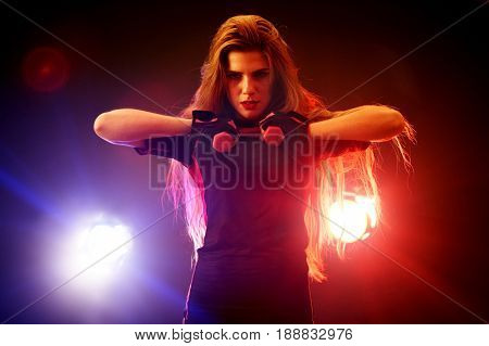 Boxing women fitness exercises in gym. Sport workout on ring .Boxer wearing red gloves to box in ring. Martial arts female in neon rays of light.
