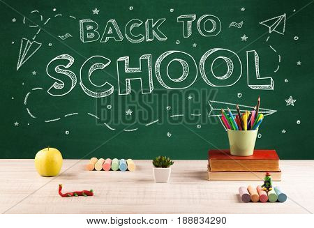 Back to school concepty with writing on blackboard and desk, apple, books, items