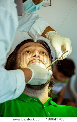 Man at the dentist clinic fixing his teeth