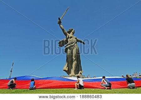 Volgograd Russia - June 12 2013: Activists unfurl a large Russian flag in Day of Russia at the foot of the monument of Motherland Calls on Mamaev hill in Volgograd