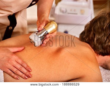 Man back massage beauty salon. Electric stimulation man skin care . Professional medical equipment microcurrent body lift . Anti aging rejuvenation . Man receiving electroporation skin care therapy .
