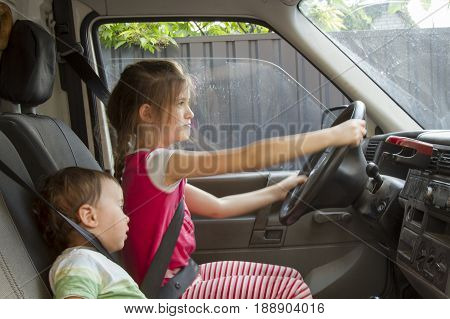 Smiling Little Brother And Sister Driving By Toy Car