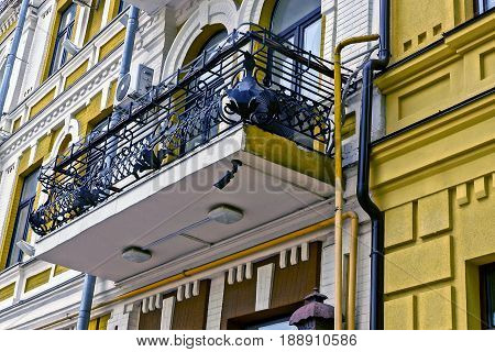 Modern balcony with iron rods and vases with dried plants on the wall of a multistory building
