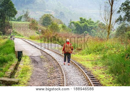 Local woman with basket moves from Bagou to Yuejin. Jiayang Mining Region. Sichuan province. China.