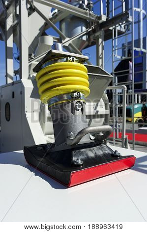 Soil compactor, vibratory rammer machine part, heavy industry, building area with construction equipment and vehicle on blurred background