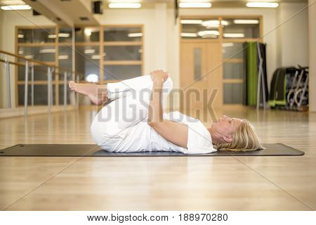 Woman In Pavanamuktasana Yoga Pose