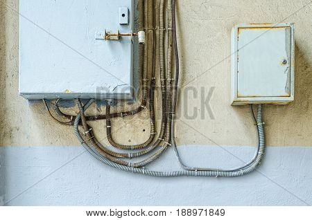 Electrical switchboard on the wall. Wiring to the electrical panel on the wall. Detail of the cityscape. Grey wall