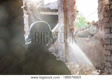 Silhouette Of A Soldier In A Helmet In The Back Light. Military Actions And Assault Of Buildings