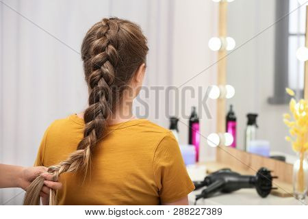 Professional Coiffeuse Braiding Client's Hair In Salon