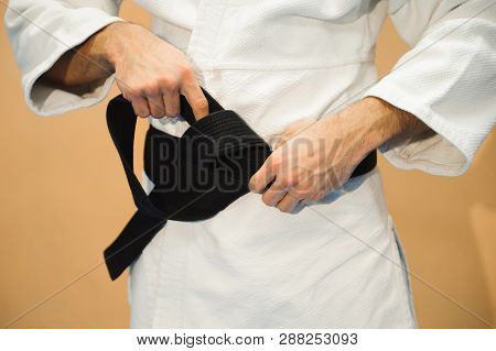 Aikido Black Belt On White Kimono In A Sport Jum