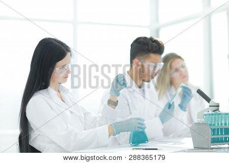 Close Up.modern Woman Sitting With Colleagues At The Laboratory Table.