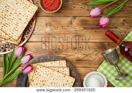 Jewish Holiday Passover Background With Matzo, Seder Plate, Wine And Tulip Flowers On Wooden Table. 