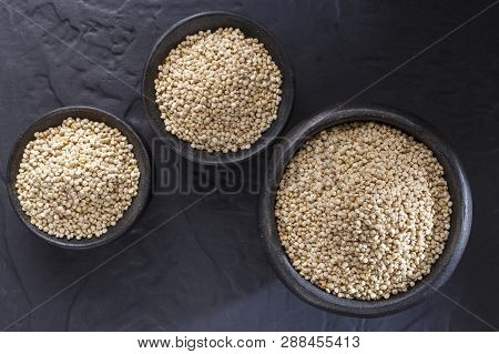 Quinoa Grains With Spoon And Bowl On Black Background