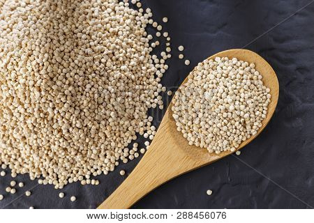 Quinoa Grains With Spoon And Bowl On Black Background