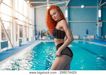 Beautiful Young Woman In The Indoor Swimming Pool. Athletic Sexy Girl. Healthy Lifestyle. Wellnes We