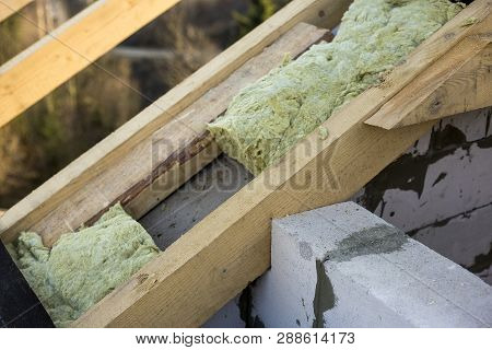 Roof Construction And Insulation With Mineral Wool. Wooden Beams Frame On Walls Of Hollow Foam Insul