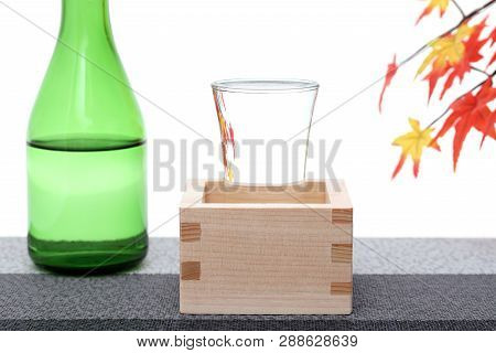 Japanese Wooden Box Masu With Sake On Table, On White Background