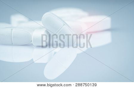 Pile Of White Oblong Tablets Pills On Gradient Background. Pharmaceutical Industry. Pharmacy Product