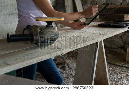 Crop View Of Female Young Adult With Portable Information Device In Hand Makes A Project  In A Carpe