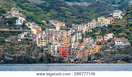Picturesque And Romantic Village Of Riomaggiore With Colourful Houses At The Edge Of A Rocky Cliff A