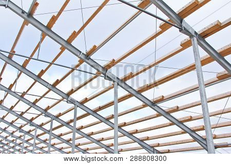 Wooden Beams On A Metal Frame. Construction Of Agricultural Buildings. The Construction Of The Barn 