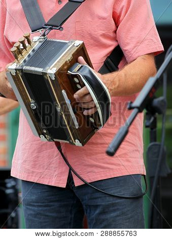 Male Zydeco Musician Performing In Concert Outdoors.