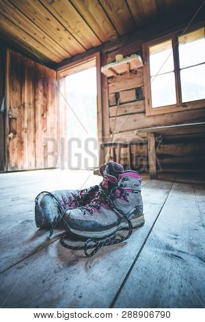 Alpine Boots On Rustic Wood Floor In An Abandoned Mountain Chalet In Austria