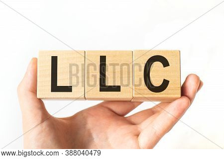 Hand Holds Wooden Cubes With Letters Llc-limited Liability Company. Business Concept Image.