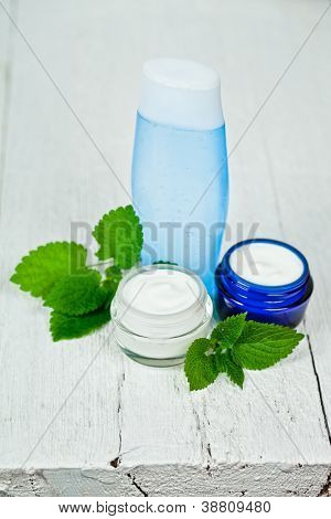 pleťový krém a krém s urtica listy záběr na bílém pozadí dřevěná