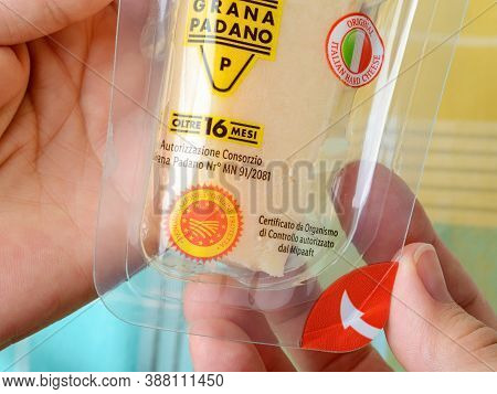 Varna, Bulgaria, October 01, 2020. Woman Hands Hold Wedge Of Italian Hard Cheese Grana Padano In A T