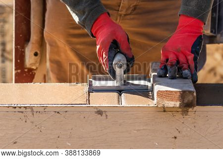 Construction Worker Using Hand Groover On Wet Cement Forming Coping Around New Pool.