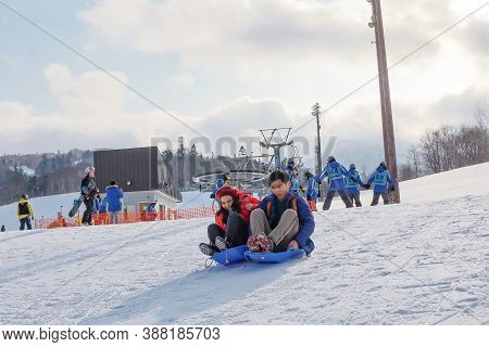 Hokkaido, Japan - December 2019 : Photo Of Love Couple Are Playing Ski Sliders Together In The Mount