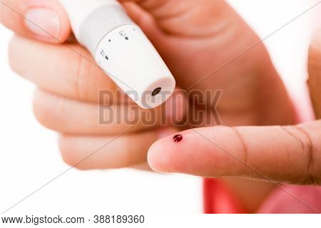 Closeup Woman Measuring Glucose Level Using A Hand Test Lancelet On The Finger She Monitors High Blo