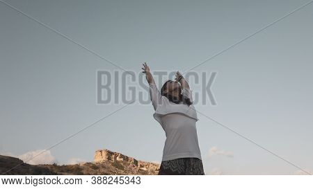 Young Woman With Outstretched Hands Doing Yoga In Early Morning On The Beach. High Quality Photo