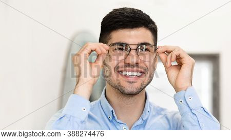 Ophthalmology And Eye Care Concept. Portrait Of Happy Male Customer Trying On New Glasses In Optics 