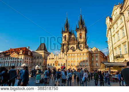 Tyn Temple On The Old Town Square In Prague. A Crowd Of Tourists Walk On The Old Town Square In Prag
