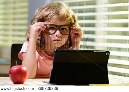 Child Boy In Glasses Using A Tablet And Study Online With Video Call Teacher At Home, Homeschooling,