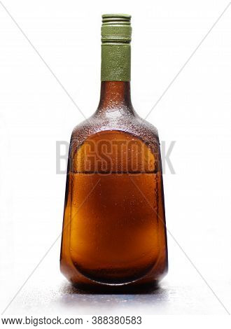 Water Drops On A Bottle Of Alcohol. On White Background