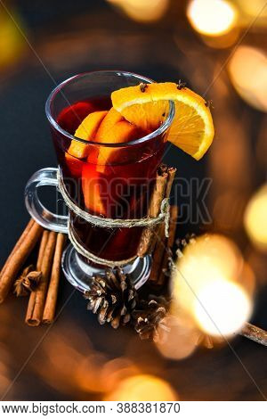 Mulled Wine Hot Christmas Drink With On A Dark Background. Orange Slices, Cinnamon Sticks, Christmas